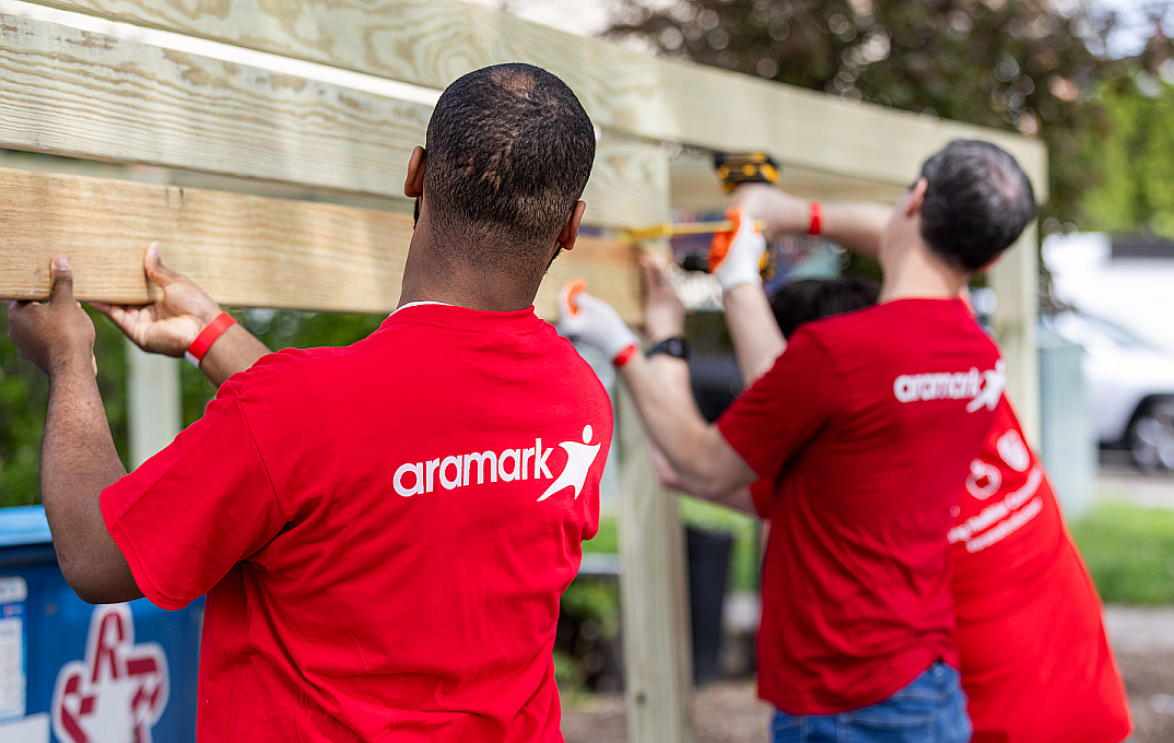 Aramark volunteers building community playground equipment
